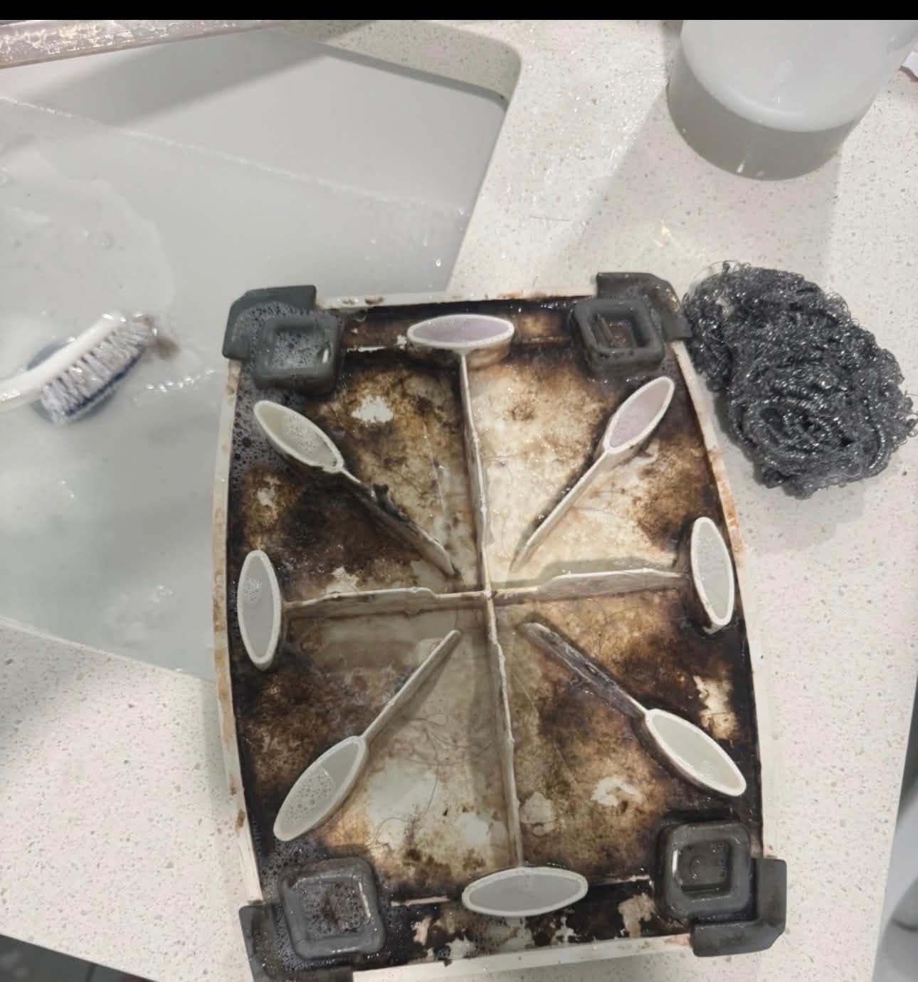 A grimy shower caddy tray before cleaning