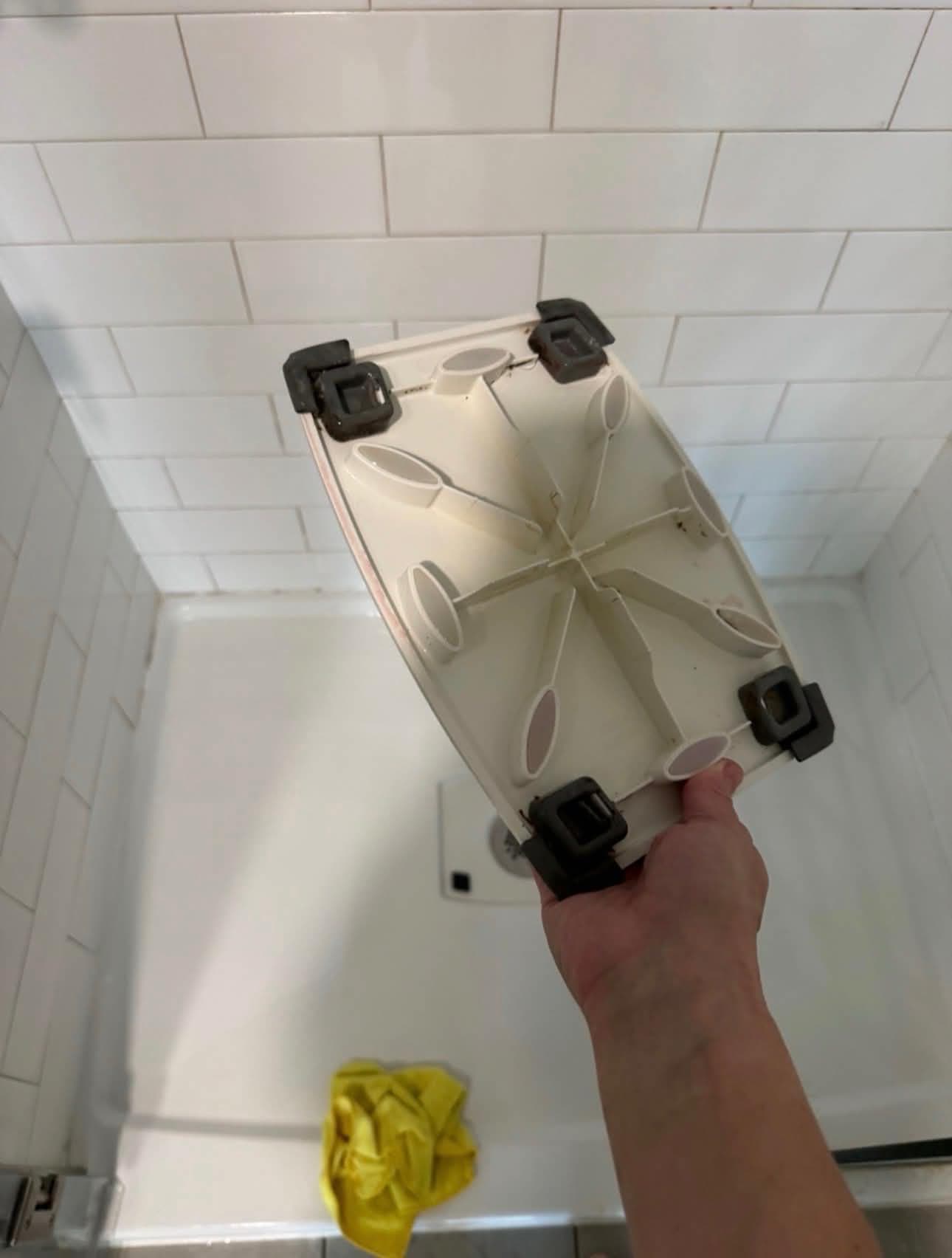 The shower caddy tray during cleaning